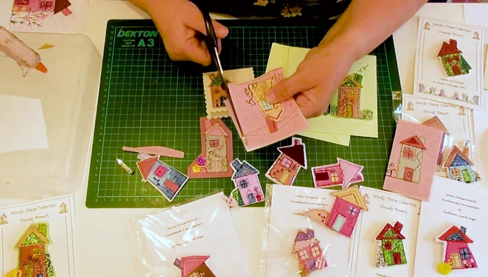 Prepare your embroidered felt house. Cut around the house, leaving raw edges.