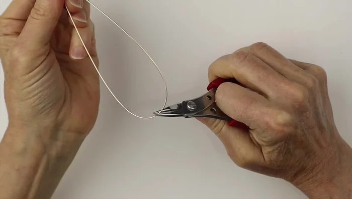 Twist one end around to close it, clip it flush, and pinch the pointy end. Then, twist this end around a ring cone to create a spiral.