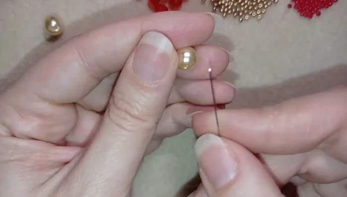 Prepare 90cm of thread and thread it onto the needle. String a pearl onto the thread, leaving a small tail.