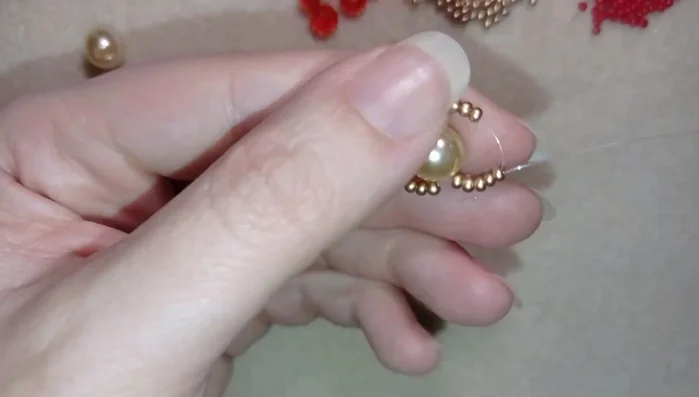 Pass the needle through all 20 beads to connect the loops, then tie off the tail thread securely with a couple of knots inside the pearl.