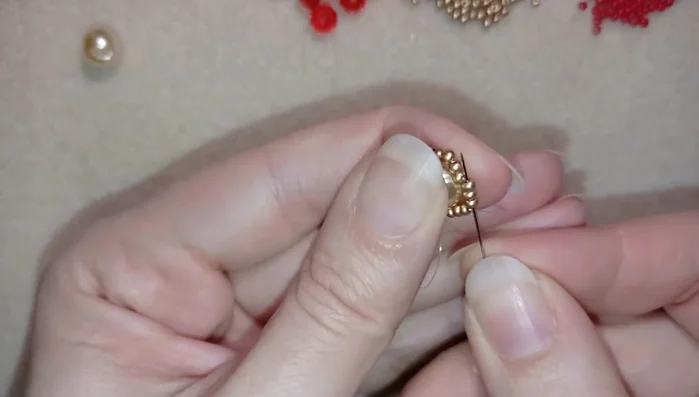 Add 21 seed beads (the video adds 20, but 21 is okay) around the pearl to form a circle.