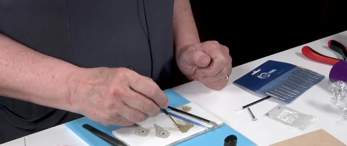 Add a small ball to the bottom of the earring using slip and applicator brushes. Reinforce three times.