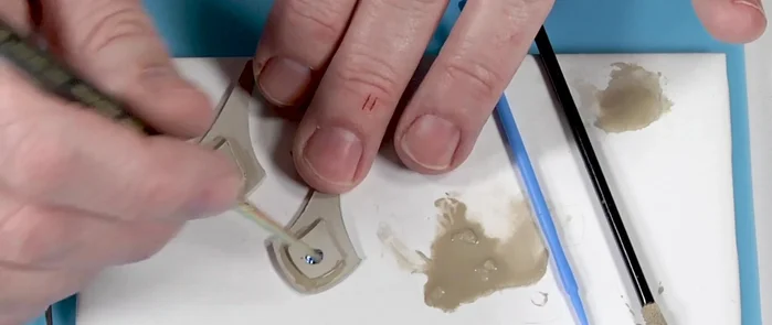 Add a small ball to the bottom of the earring using slip and applicator brushes. Reinforce three times.
