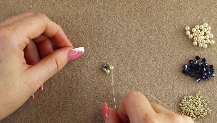 Begin the Russian spiral stitch: Based on the bead following the thread exit point, pick up the next set of three beads (two 11/0 seed beads and the next larger bead, either pearl or fire polish) and stitch through the first 11/0 bead after the just-added larger bead. Repeat this step, always choosing the next bead set based on the bead the thread exits after.