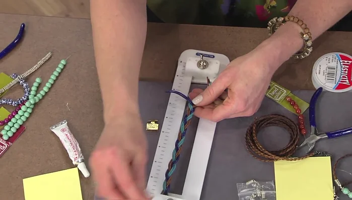 Apply glue to the inside of the clasp, insert the braid ends and press flat.