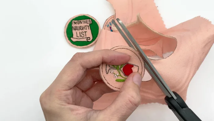 Apply glue stick to the other side of the plastic circle. Attach the front of your design to the plastic, pressing firmly.