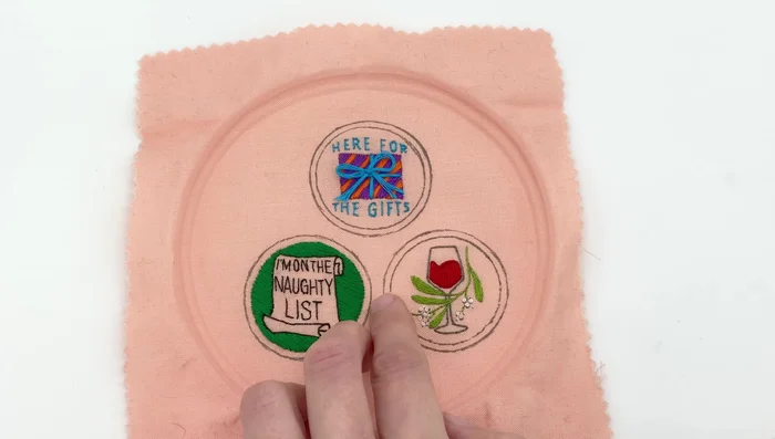 Apply fabric glue to one side of the felt circle and press it onto the back of your design, tucking in loose threads.