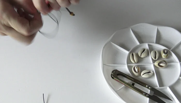 Create the bracelet base: Tie a knot a short distance from the bead to mark the beginning of the bracelet.