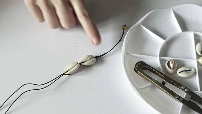Repeat Step 4: Continue adding cowrie shells, repeating the knotting technique until you reach the desired bracelet length.