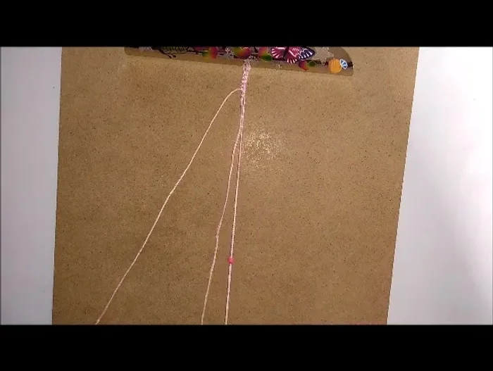 Push the bead up to the hitch knots.