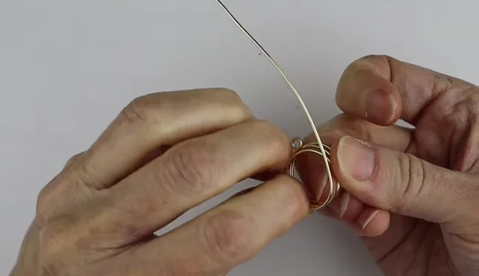 To finish the back, clip and turn the wire ends, or wind them around. Clip and turn method involves creating small loops at the back and flattening them with flat pliers to create a flush finish. 