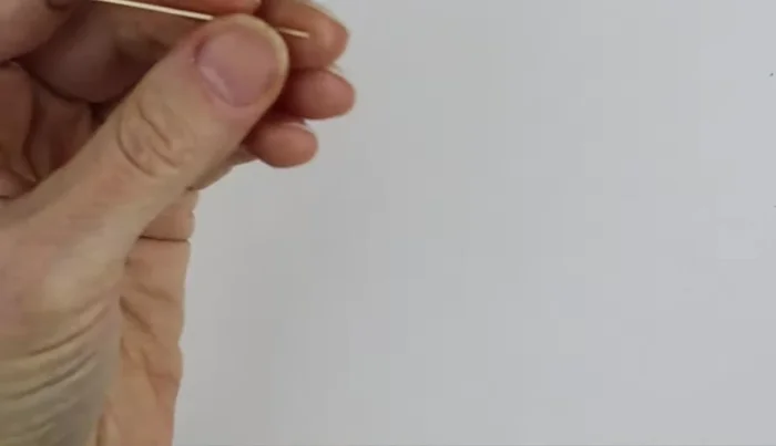 Cut a short piece of 20 gauge wire (or use a head pin). Create a small loop on one end using round pliers.