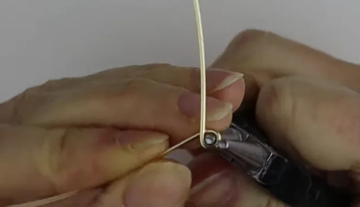 Shape the wire into a ring using your finger as a guide. Use the ring cone to determine the desired size and wrap the wire once above and once below the cone for centering.