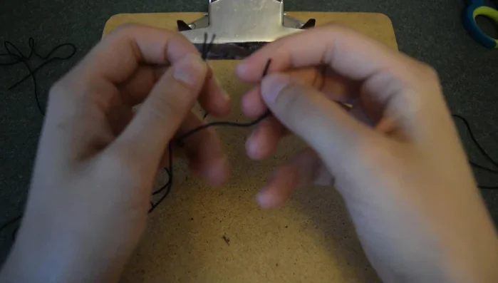 Tie the three strands together with an overhand knot. Secure the ends to a clipboard (or use tape).