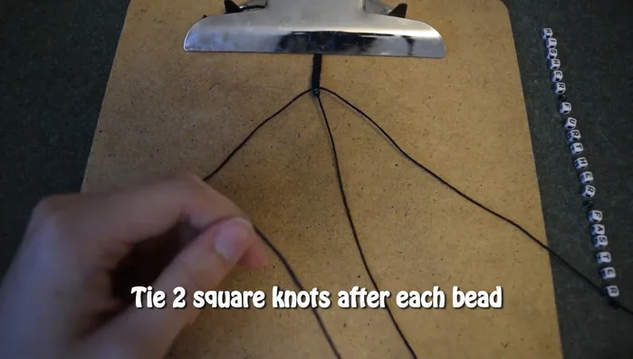 After each bead, tie two square knots to secure it. Repeat this process for all the beads.