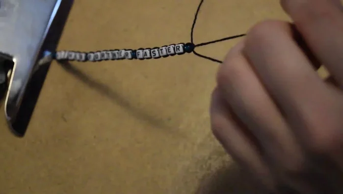 Tie approximately one inch of square knots after all beads are added.