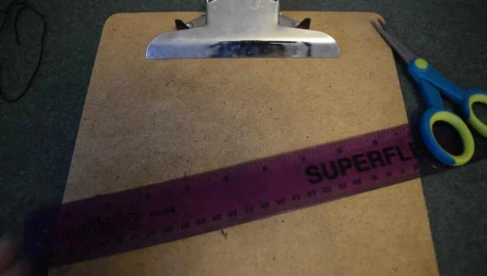 Tie the three strands together with an overhand knot. Secure the ends to a clipboard (or use tape).