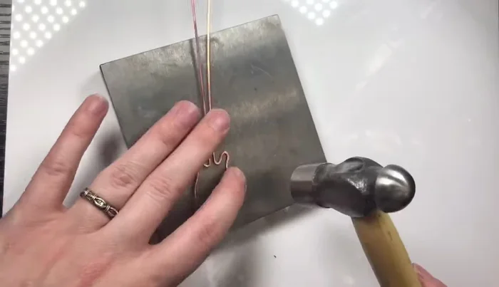 Hammer the guitar body gently to strengthen it without flattening the wire too much.