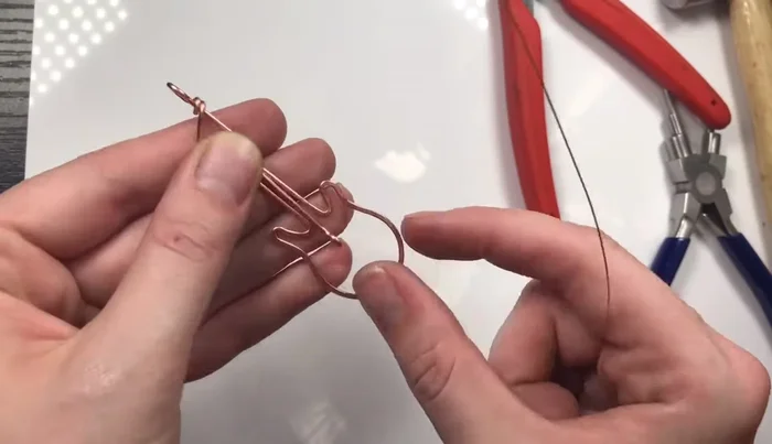 Weave the eye pin into the guitar head and neck using 26 gauge weaving wire. Adjust loop size if needed for a snug fit.