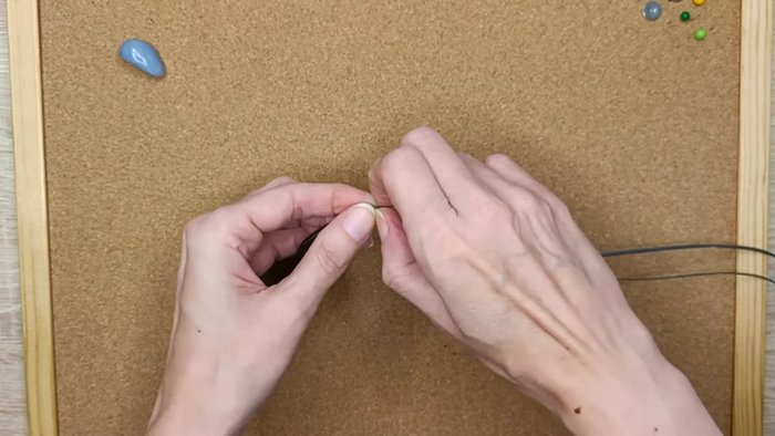 Pin down the strings, making a knot on the other side.