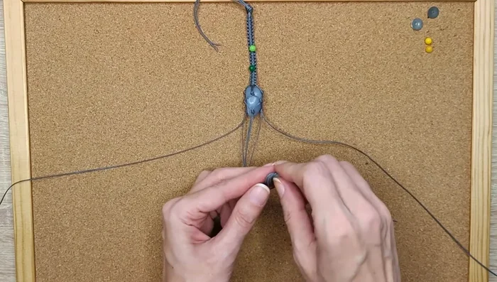 Secure the four shorter strings with a knot and continue making square knots to complete the bracelet band.