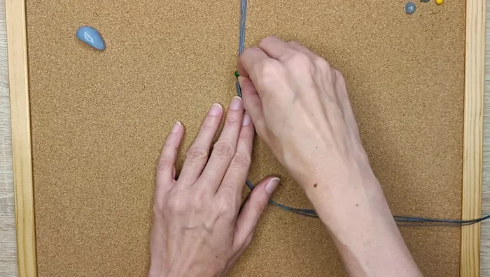 Pin down the strings, making a knot on the other side.