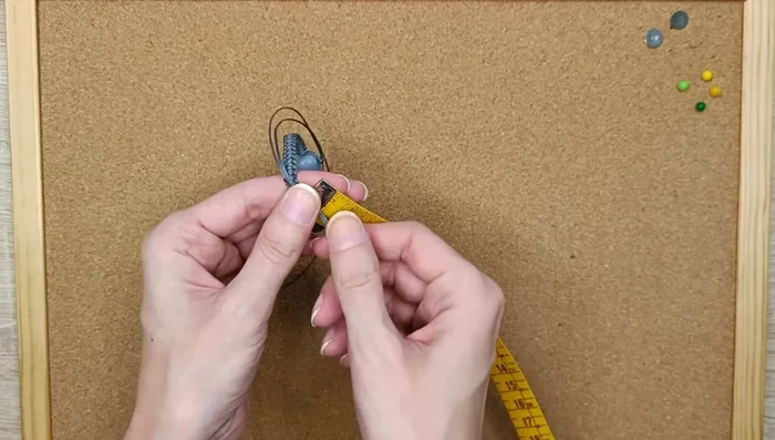 Measure 5cm on each side of the bracelet and make an overhand knot to make it adjustable.