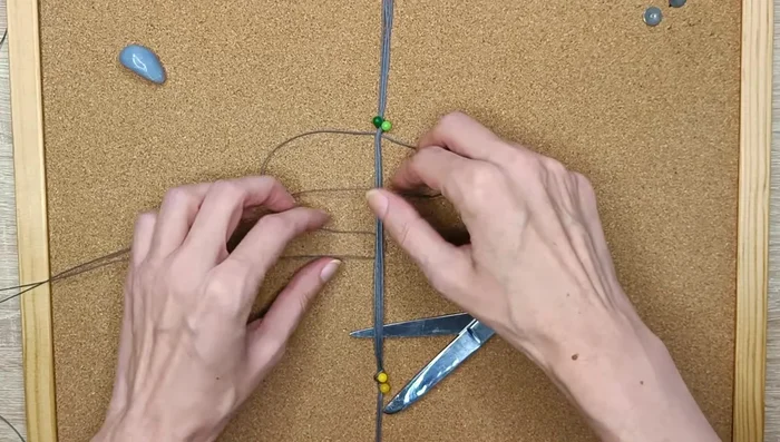 Secure the four shorter strings with a knot and continue making square knots to complete the bracelet band.