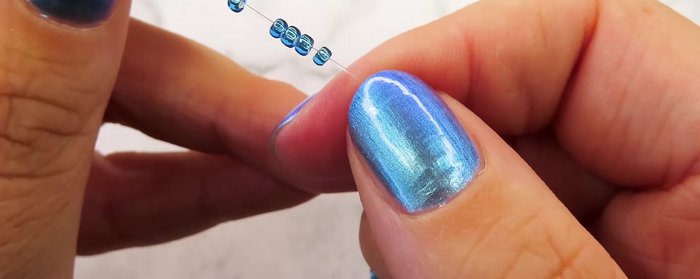 Tie two knots to secure the first flower.