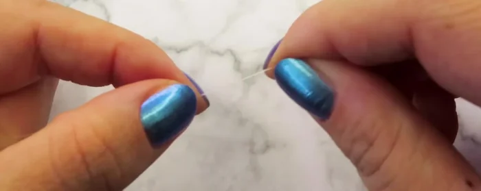 Add 7 beads and pull the cord through the two beads from the previous petal, then the white bead and the next one.