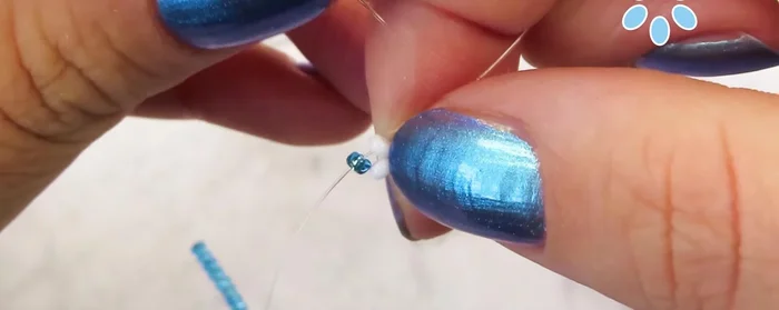 Add 7 beads and pull the cord through the two beads from the previous petal, then the white bead and the next one.