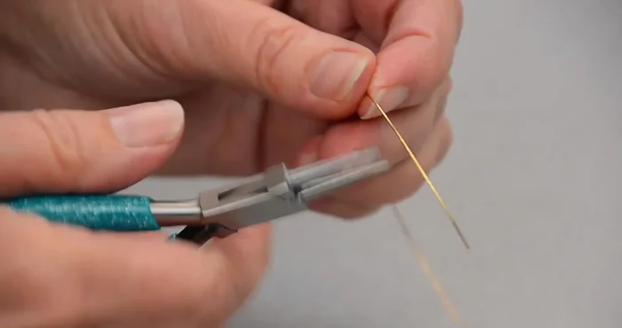 Make the connector: Cut a 4-5 inch piece of 24 gauge wire. Create a loop at one end using the same technique as step 2. Slide this loop onto the opposite side of the ring.