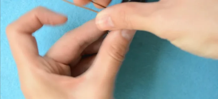 Wrap the wire twice around a cylindrical object, ensuring the tails face opposite directions.