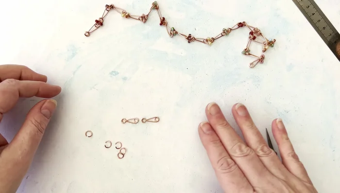 To join links, use jump rings. Add one bead to each side of the jump ring before attaching to the links. Ensure all links face in the same direction for a consistent look.