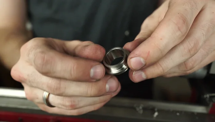 Refine the titanium ring edge on the lathe to ensure a proper fit with the koa wood.