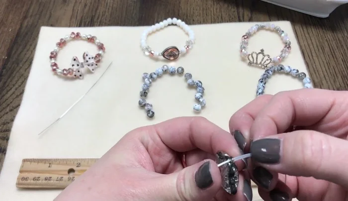 Create slip knots: Thread one end of each cord through one loop of a connector. Make a small loop and pull the cord ends through the loop to form a slip knot. Repeat on both sides of the connector.