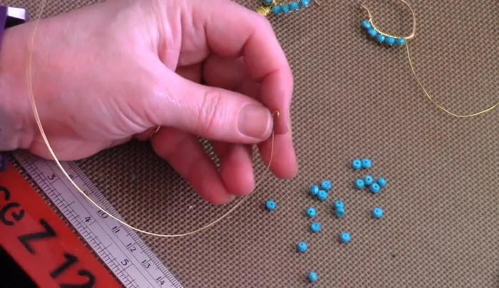 Wrap the center bead: Wrap the two wires down the sides of the briolette bead, creating a rustic wrap by wrapping multiple times. Trim excess wire and tuck in the ends.