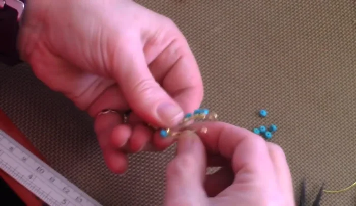 Continue beading: Add beads to the other side, following the same pattern. If wire runs short, add more wire by wrapping it securely and continuing the beading process.