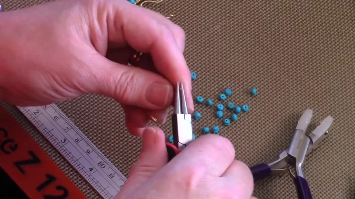 Shape the frame: Curl down the edges to form two loops for the ear wire. Use fingers, a dowel, or ring mandrel to shape it evenly.