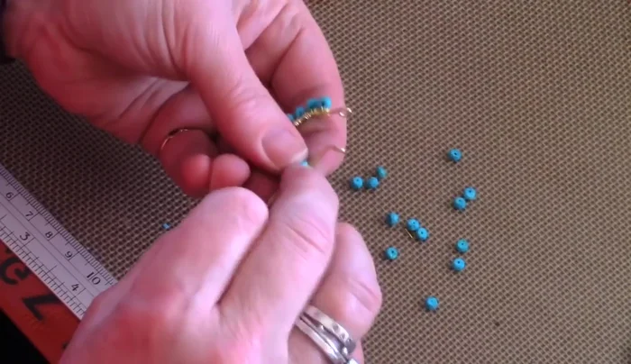 Finish beading: After adding all the desired beads, wrap the wire securely, trim the excess, and tuck in the ends.