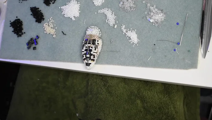 Create the spider's legs using thin wire, alternating tiny seed beads and sequins.