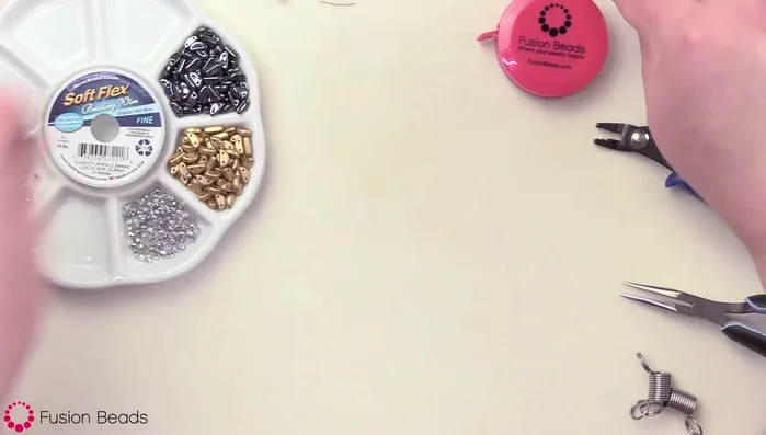 Prepare four 10-inch strands of beading wire. Attach two strands to each loop of the clasp.