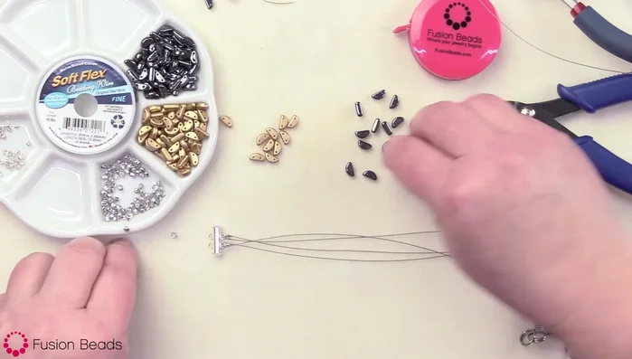 String all four strands simultaneously. Begin the pattern with a hematite half-moon bead, ensuring the half-moon faces upwards consistently. Thread each strand through alternating holes of the bead.