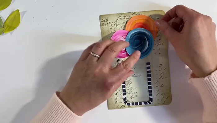 Arrange and glue the flower arrangement onto the vintage ledger page.