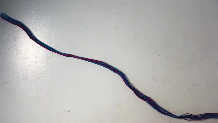 Tie a knot at one end of all nine strings, braid them, then tie another knot to create an adjustable closure.