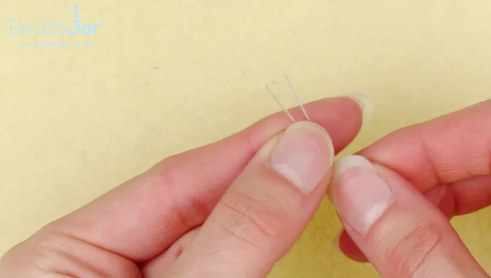 Cut two 30cm lengths of cable wire. Thread both wires through the loop at the top of the sterling silver star charm.