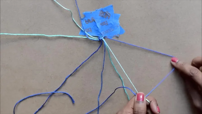 Reverse knotting: Switch to the same colored strand on the right. This time, form a backward four over the adjacent strand. Create two knots and move to the next strand, working your way inward until you reach the center.