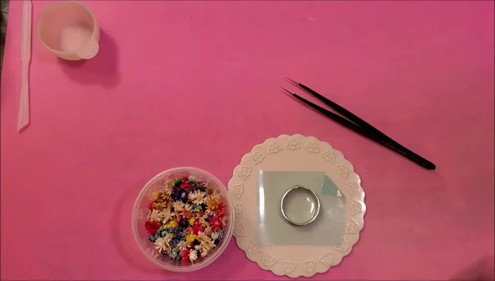 Place the flowers (upside down) onto the cured resin ring, add another layer of clear resin, remove bubbles using a heat gun, and cure for 90 seconds.