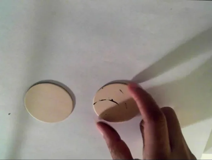 Trace a face shape onto the wood using a button, coin, or freehand drawing.
