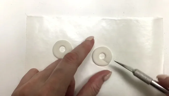 Use an exacto knife to cut two straight lines to create the earring hoops.